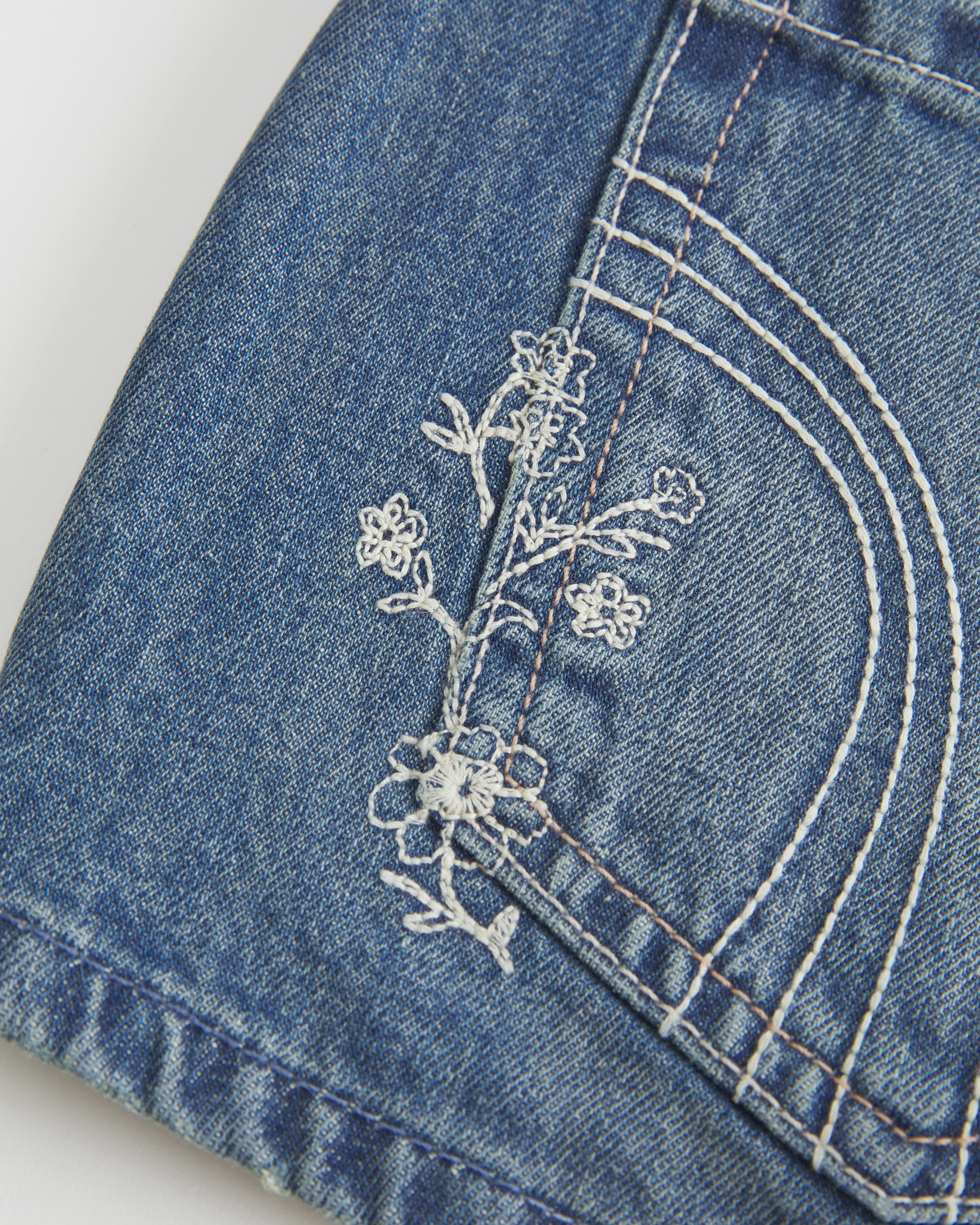 Ultra Low-Rise Medium Wash Floral Embroidered Denim Mini Shorts